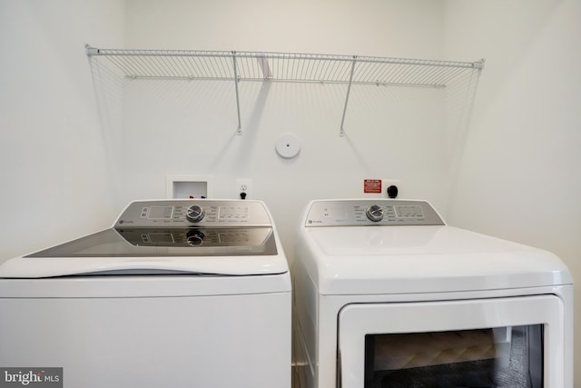 clothes washing area with washing machine and dryer