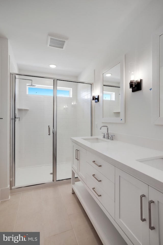 bathroom featuring tile patterned flooring, vanity, and a shower with shower door