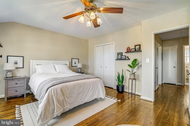 bedroom with ceiling fan, vaulted ceiling, dark hardwood / wood-style flooring, and a closet