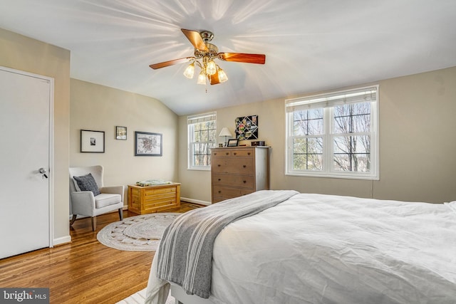 bedroom featuring hardwood / wood-style flooring, vaulted ceiling, and ceiling fan