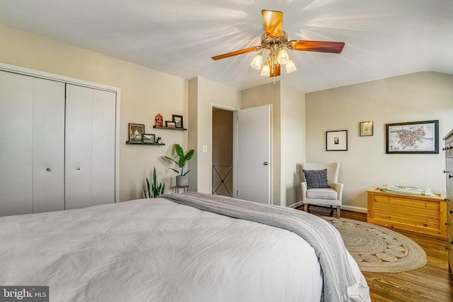 bedroom featuring hardwood / wood-style flooring, ceiling fan, lofted ceiling, and a closet