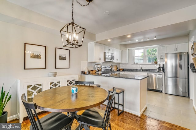 dining room with sink and a notable chandelier