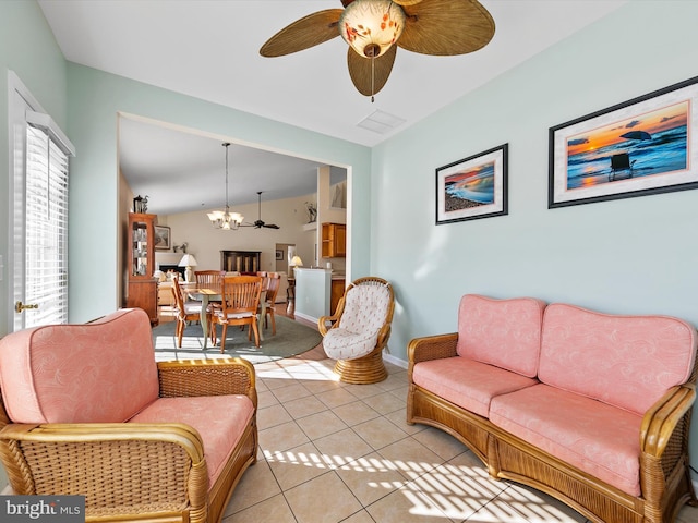 living room featuring ceiling fan with notable chandelier and light tile patterned floors