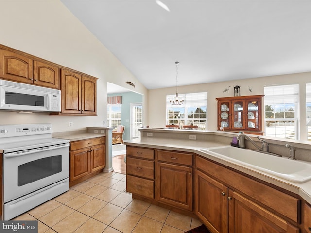 kitchen featuring pendant lighting, sink, white appliances, light tile patterned floors, and an inviting chandelier