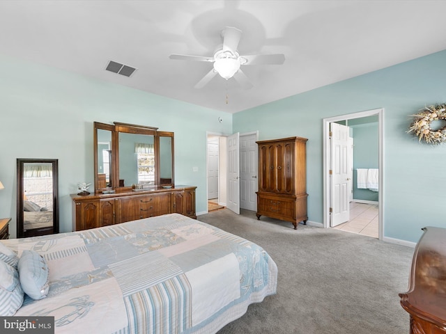 bedroom with multiple windows, connected bathroom, light carpet, and ceiling fan