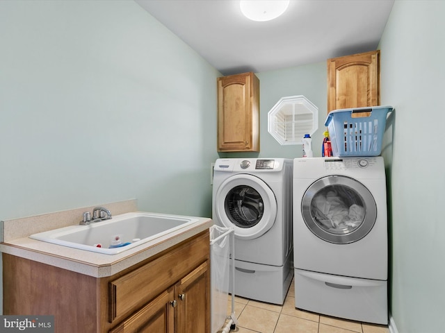 clothes washing area featuring cabinets, separate washer and dryer, sink, and light tile patterned floors