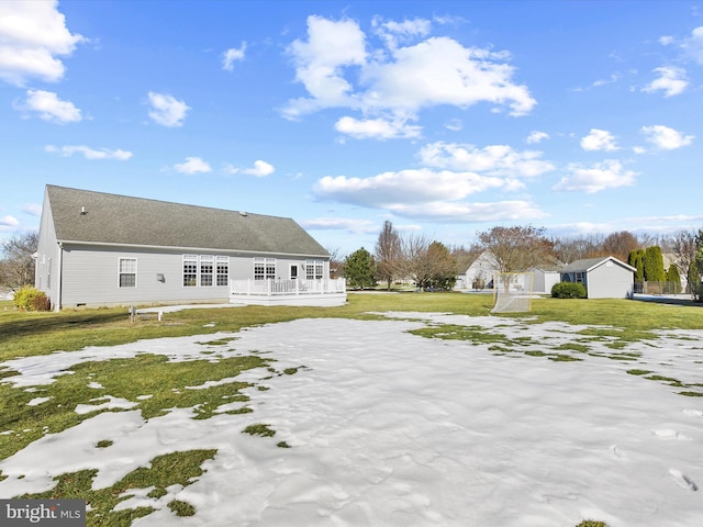 rear view of house featuring a yard, a deck, and a storage unit