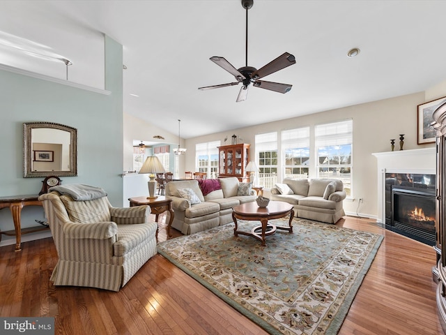 living room with hardwood / wood-style flooring, a fireplace, ceiling fan, and vaulted ceiling