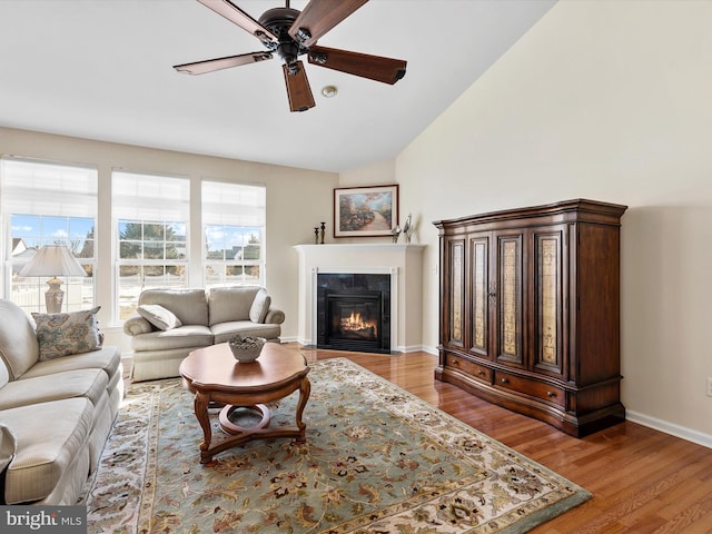 living room with lofted ceiling, hardwood / wood-style floors, and ceiling fan