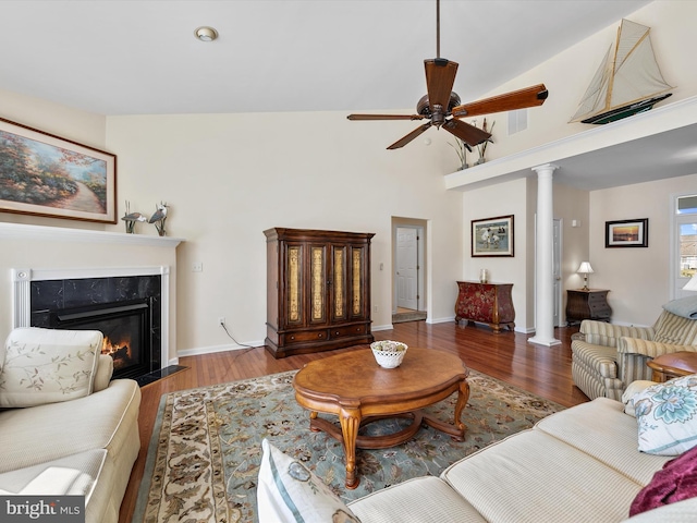 living room with ceiling fan, a fireplace, wood-type flooring, and ornate columns