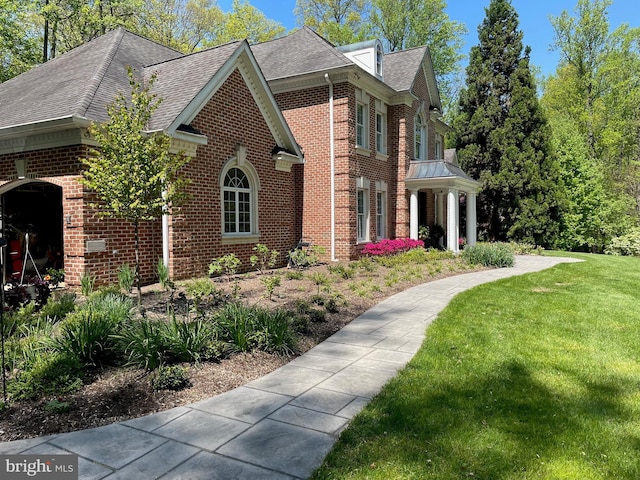 view of side of property with a garage and a lawn