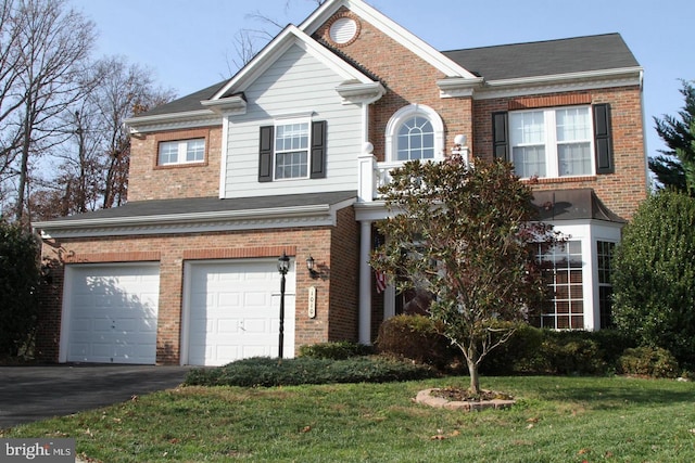 traditional home featuring a front lawn, an attached garage, brick siding, and driveway