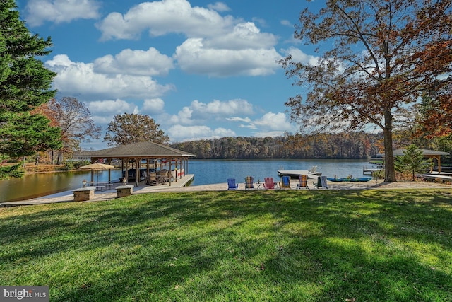 view of dock featuring a gazebo, a water view, and a yard