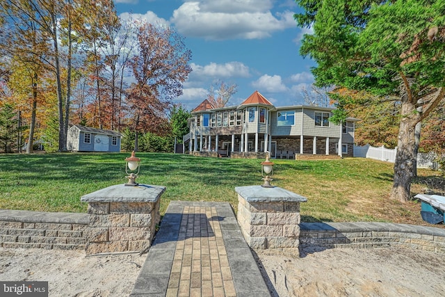 back of house with a yard, a patio area, and a storage shed