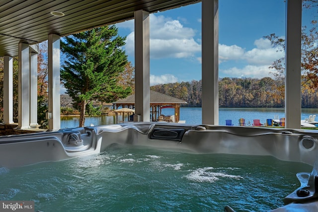 view of swimming pool featuring a water view, a hot tub, and a gazebo