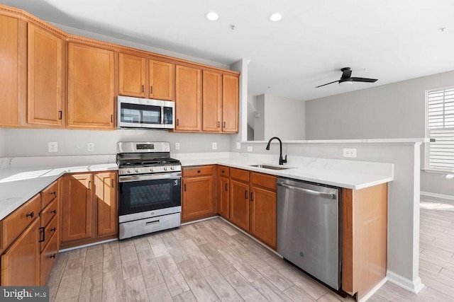 kitchen with ceiling fan, stainless steel appliances, light wood-style floors, a sink, and recessed lighting