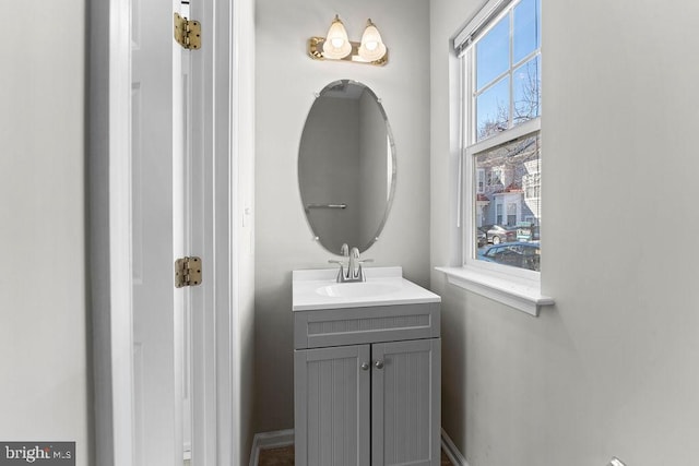 half bath with vanity and baseboards