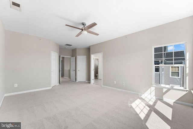 unfurnished room featuring light carpet, a ceiling fan, visible vents, and baseboards