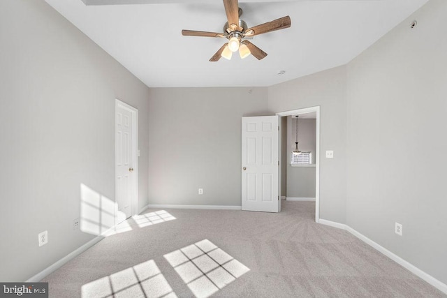 unfurnished bedroom with a ceiling fan, light colored carpet, and baseboards