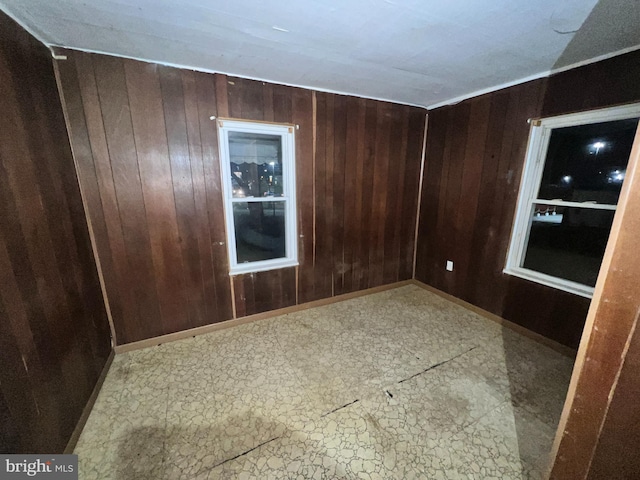 unfurnished room featuring wood walls