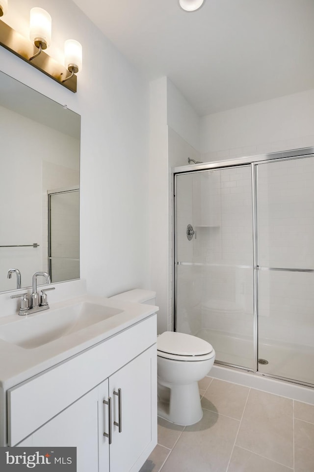 bathroom featuring an enclosed shower, vanity, tile patterned floors, and toilet