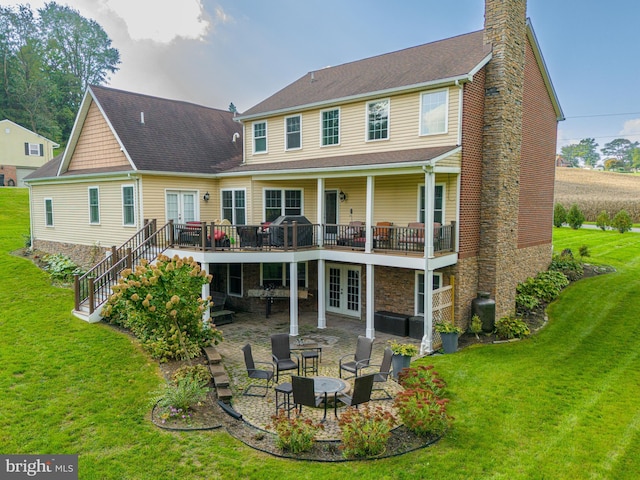 back of house featuring a wooden deck, a yard, a patio, and french doors