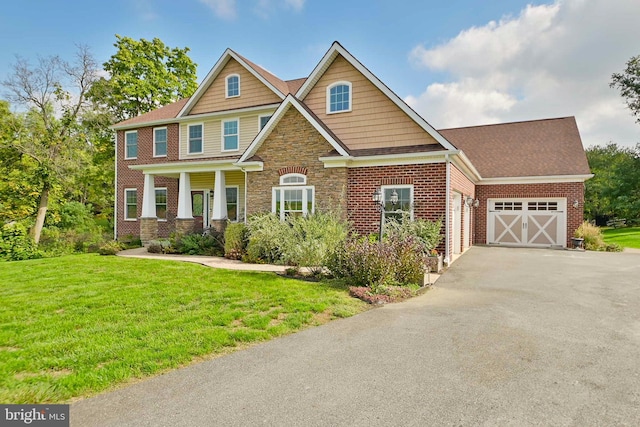 craftsman-style house with a garage, a front yard, and covered porch