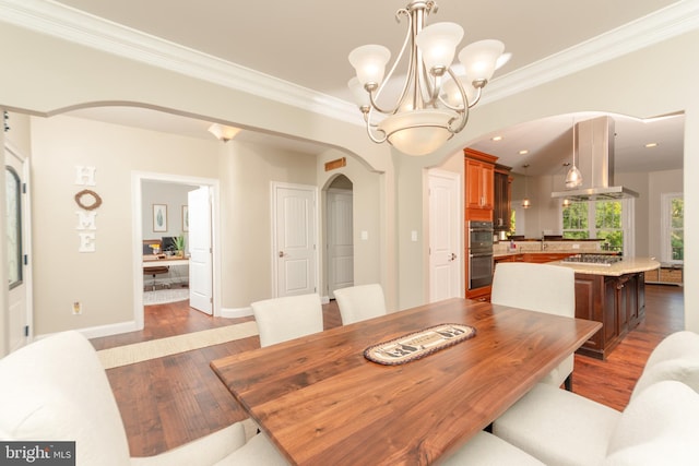 dining area featuring an inviting chandelier, ornamental molding, dark hardwood / wood-style floors, and sink