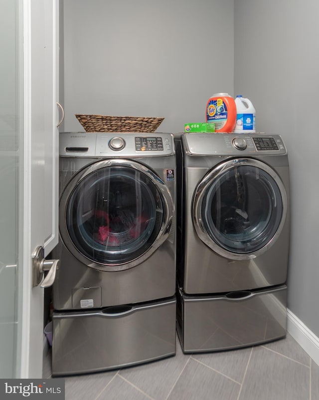 washroom featuring washer and clothes dryer and light tile patterned floors