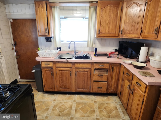 kitchen with black range, sink, and decorative backsplash