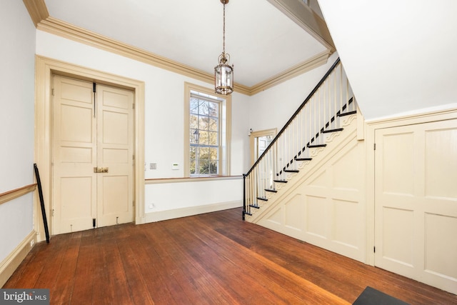 foyer entrance featuring ornamental molding, dark hardwood / wood-style flooring, and a notable chandelier