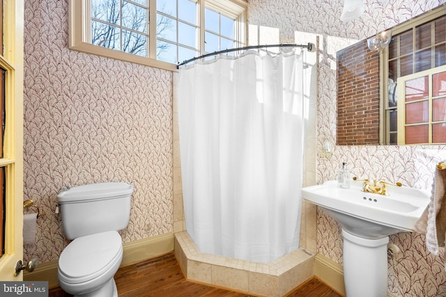 bathroom with hardwood / wood-style flooring, toilet, and a shower with shower curtain