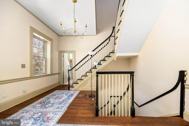 stairway featuring an inviting chandelier and hardwood / wood-style floors