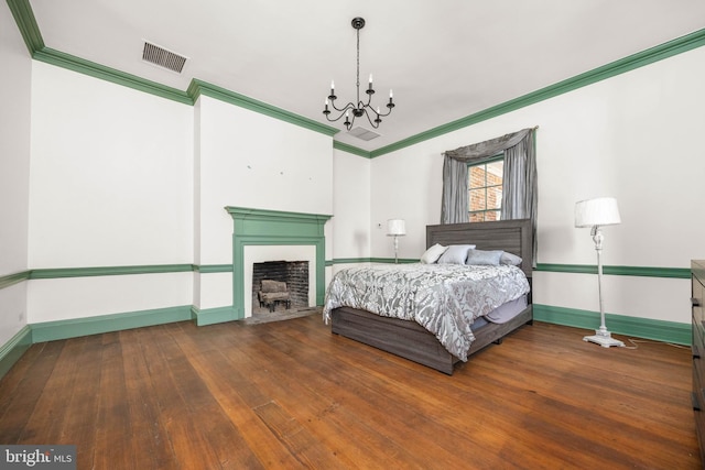 bedroom featuring an inviting chandelier, ornamental molding, and wood-type flooring