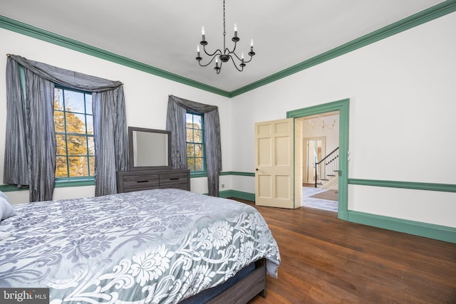 bedroom featuring crown molding, dark hardwood / wood-style flooring, and a chandelier