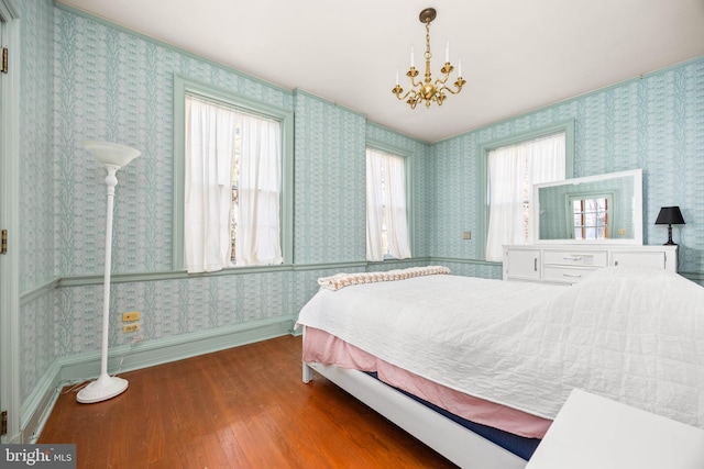 bedroom with an inviting chandelier and hardwood / wood-style floors