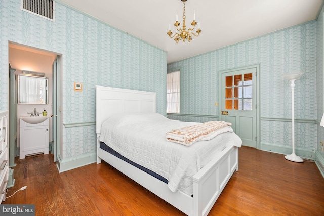 bedroom with dark hardwood / wood-style flooring and a chandelier