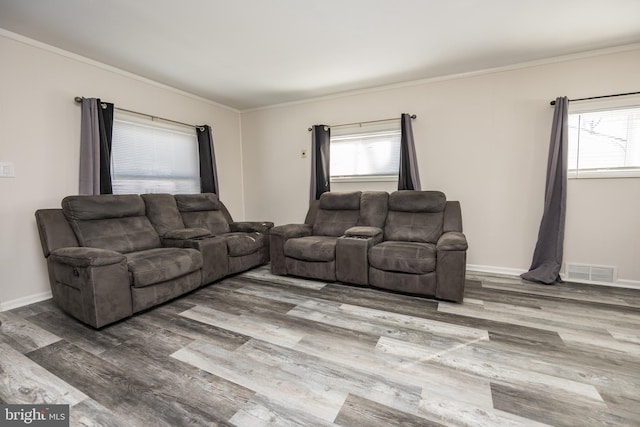 living room with ornamental molding, plenty of natural light, and hardwood / wood-style floors