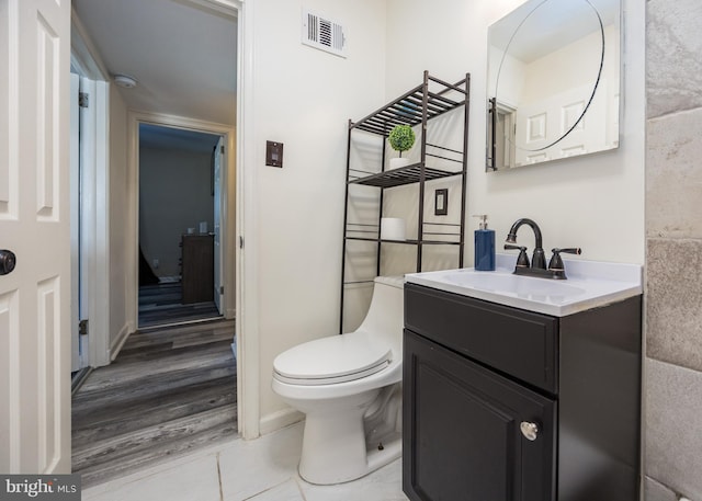 bathroom featuring vanity, wood-type flooring, and toilet