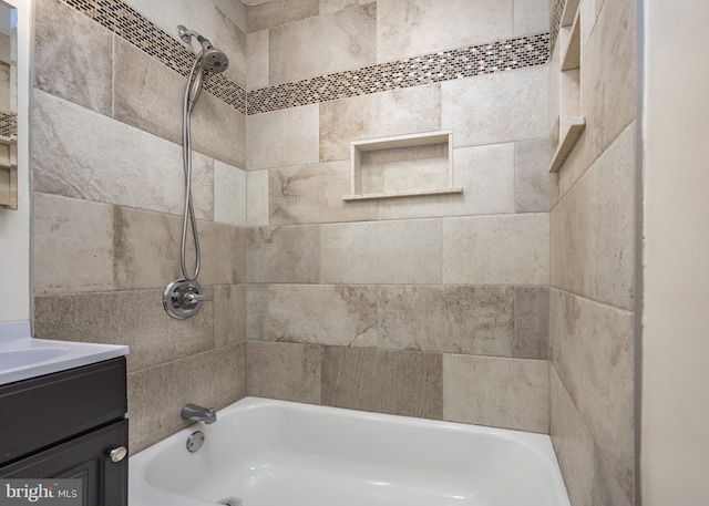 bathroom with tiled shower / bath combo and vanity