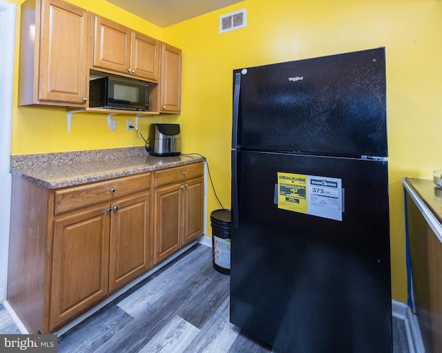 kitchen with dark wood-type flooring and black appliances