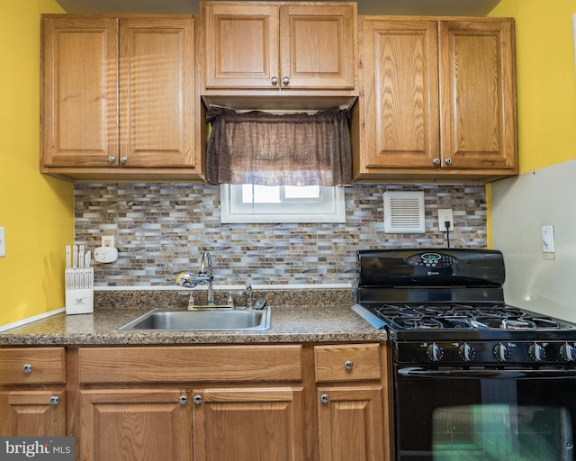 kitchen featuring black range with gas stovetop, sink, and decorative backsplash