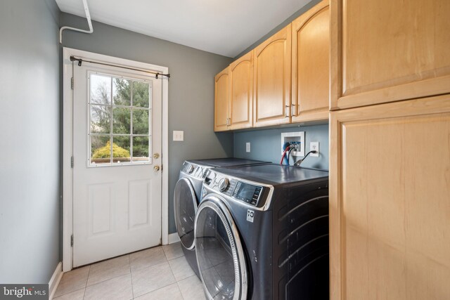 washroom featuring cabinets, light tile patterned flooring, and washing machine and clothes dryer