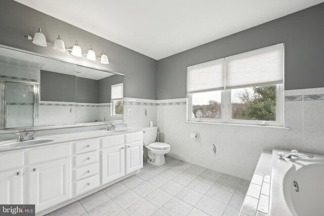 full bathroom featuring tile patterned flooring, vanity, separate shower and tub, and tile walls