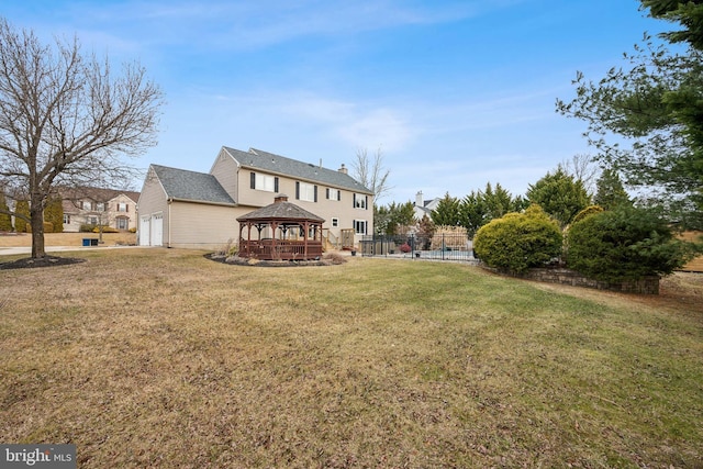 rear view of property featuring a gazebo and a lawn