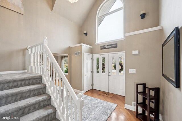 entryway featuring wood-type flooring and high vaulted ceiling