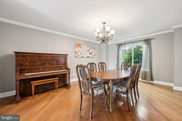 dining space featuring ornamental molding, light hardwood / wood-style floors, and a notable chandelier