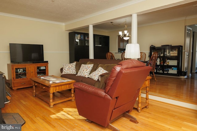 living room with wood-type flooring, ornamental molding, a textured ceiling, and a chandelier