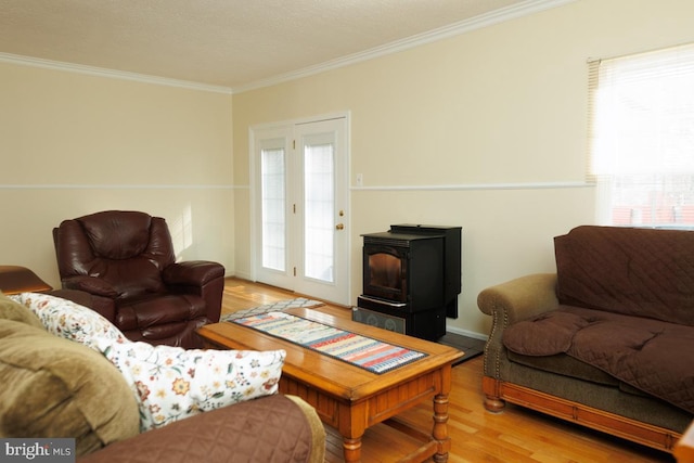 living room featuring wood-type flooring, ornamental molding, and a wood stove