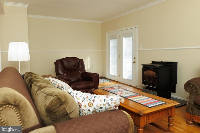 living room with hardwood / wood-style floors, ornamental molding, and a wood stove